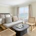 Pacific Edge Hotel in Laguna Beach guest room with ocean view, bed, sofa, and wicker chairs