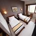 Hotel Nyland Pasteur Bandung room with two single beds, desk, chairs and window in Bandung