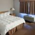 Motel 6 Norway MI guest room with queen bed, bedside lamps, and window air conditioner in Norway