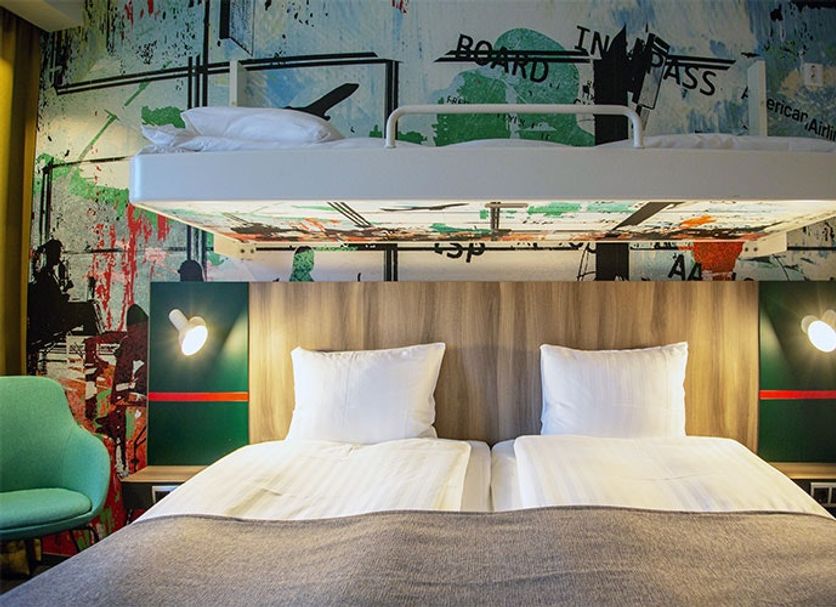 Good Morning Arlanda guest room with bunk bed over twin beds and graffiti-style wall art