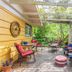 The Stella Rose B&b in Wolfville: pergola-covered patio with chairs, potted flowers and lush greenery