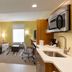 Home2 Suites by Hilton Gainesville Medical Center suite with kitchenette, sofa, desk and sitting area in Gainesville