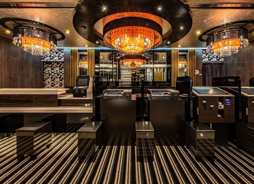 Apa Hotel Kyoto Eki Horikawadori lobby with ornate ceiling lights and striped carpet in Kyoto