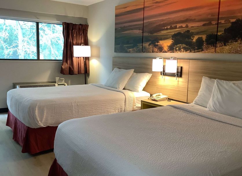 Days Inn by Wyndham Kingdom City guest room with two beds, window, and landscape wall art