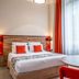 Aparthotel Adagio Lyon Patio Confluence room with red accents, double bed, and round table in Lyon