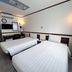 Toyoko Inn Cebu in Mandaue City guest room with two twin beds, wall-mounted TV, and floor lamp