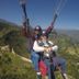 Nagarkot Bed & Breakfast guests paragliding over green mountain hills and valleys in Nagarkot