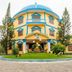 Palmira Beach Resort & Spa in Phan Thiet, a colorful round resort building with palm trees and lawn
