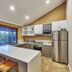 Eight Willows Retreat kitchen with island, stainless steel fridge, and large window views in Metricup