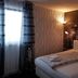 Hotel Ackermann in Riedstadt guest room with bed, cityscape wall mural and window curtains