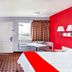 OYO Hotel Houston Southwest I-69 room with TV, desk, window view and red accent wall in Houston