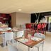 Campanile Grenoble Sud - Seyssins bar and dining area with tables, white chairs, and red bar stools.