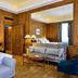 Pousada de Lisboa Lisbon luxury room with wood-paneled walls, large bed, seating area and mirrored wall