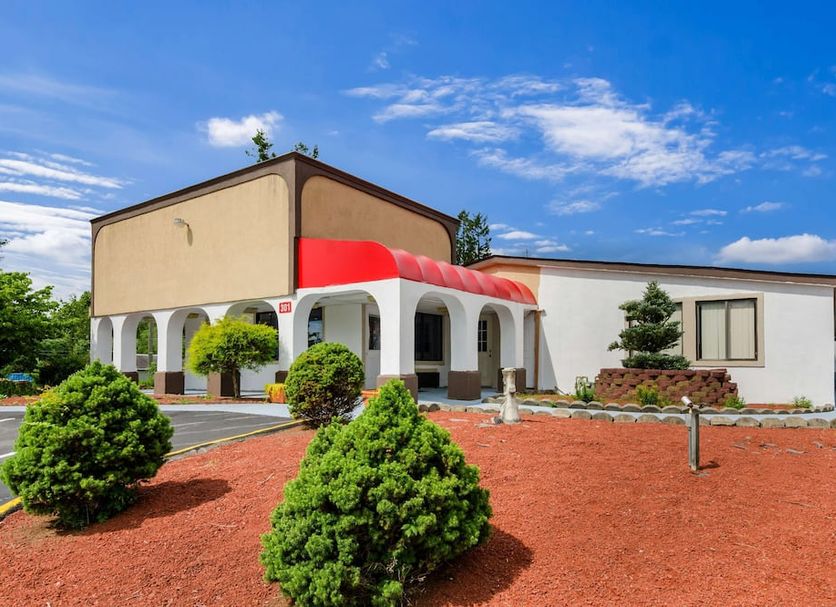 Motel 6 Salem, Va exterior with arched entrance, red awning, and landscaped grounds in Salem