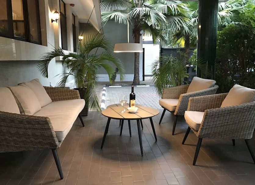 Nordic Villa Abuja outdoor lounge with wicker chairs, coffee table and tropical plants