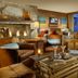 The Osprey at Beaver Creek lounge with stone fireplace, leather chairs and mountain-view window