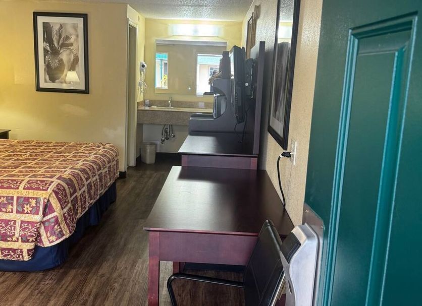 Somatel Goodlettsville guest room with king bed, desk, TV, and bathroom vanity visible