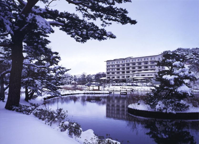 Kagamigaike Hekizantei in Nihonmatsu, overlooking a snowy pond with a reflected hotel building