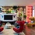 citizenM Austin Downtown lounge with red chairs, black fireplace, wall art and city-view windows in Austin