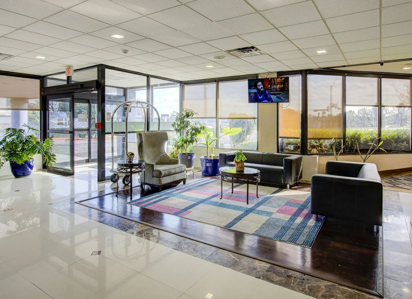 Lobby seating area at Capital O Duncanville Tx in Duncanville with large windows and potted plants
