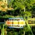 Dalyan Terrace Hotel in Dalyan, Mugla, overlooking a calm river with a colorful boat and wooded hillside