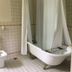 Spread Eagle Tavern and Inn bathroom with clawfoot tub, pedestal sink and tiled walls in Hanoverton