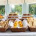 Breakfast buffet at Pousada Viana do Castelo in Viana do Castelo with baskets of pastries and fruit by windows
