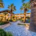 Olive Garden Hotel in Lardos with palm-lined garden paths and a lit resort building at dusk