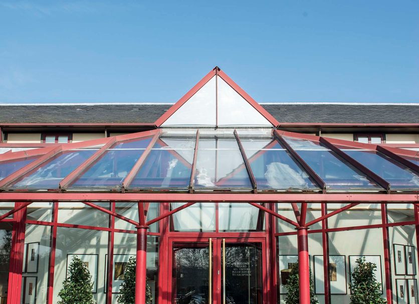 De Vere Latimer Estate in Chesham, glass-roofed entrance walkway with red-framed doors