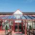 De Vere Latimer Estate in Chesham, glass-roofed entrance walkway with red-framed doors