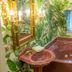 Fairfield Manor Bed and Breakfast in Shreveport bathroom with jetted tub, sink and tropical wallpaper