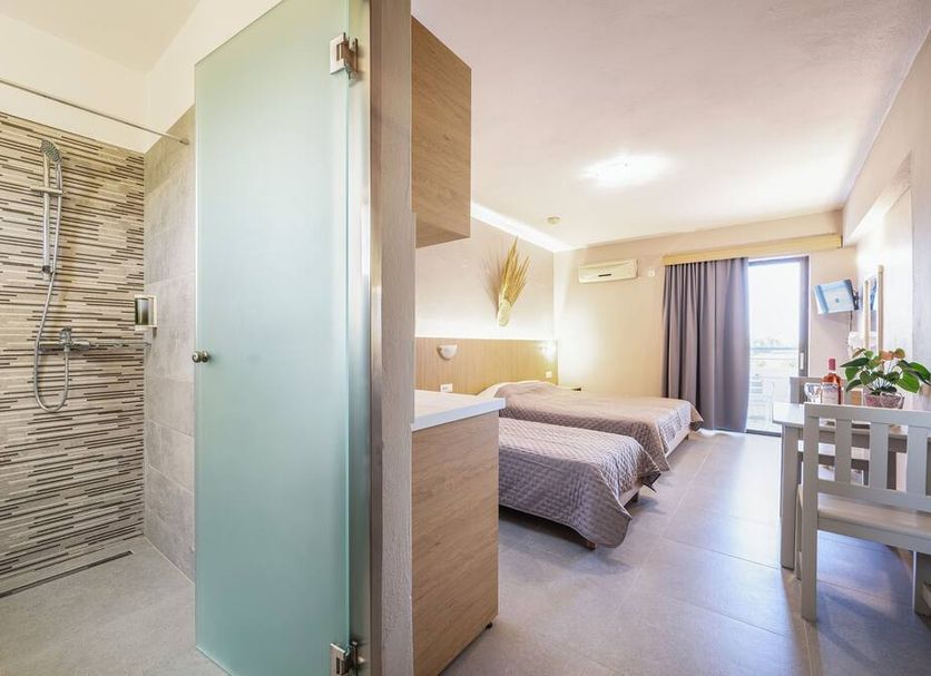 Oasis Tigaki room with twin beds, balcony door, and walk-in shower in Tigaki