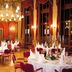 Dormero Hotel Dresden City in Dresden ballroom with chandeliers, red drapes and set dining tables
