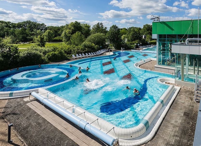 Akzent Hotel Berlin in Bad Bevensen with outdoor pool and swimmers beside a modern glass building