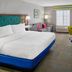 Hampton Inn Kansas City The Legends guest room with king bed, sofa, desk, TV and window seat