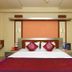 Hotel NavaRATNA, Coimbatore: guest room with a double bed, red accents, and bedside tables