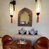 Riad Jardin Des Rêves in Marrakech seating area with leather chairs, carved mirror, and wall lanterns