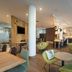 Citadines Arnulfpark Munich lounge and dining area in Munich with green chairs and wooden tables