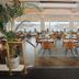 Hotel Noordzee in Katwijk dining room with wooden tables, woven chairs, and large windows
