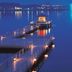 Ooedo Onsen Monogatari Wanwan Resort Yataya Shotoen in Kaga, illuminated pier over calm water at dusk