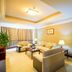 White Dolphin Hotel in Qinzhou living room with sofa, armchairs, lamps, and doorway to bedroom