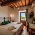 Villa Di Sotto in Castelnuovo Berardenga: rustic bedroom with wrought-iron bed and countryside view