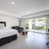 Hotel Nicte in Managua guest room with king bed, sofa, and sliding glass doors to a patio