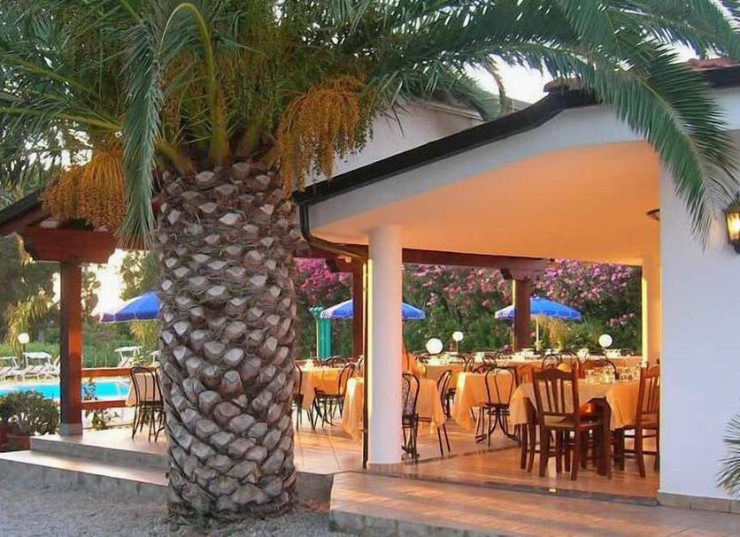 C'Era Una Volta in Ricadi with palm-framed outdoor dining beside a pool