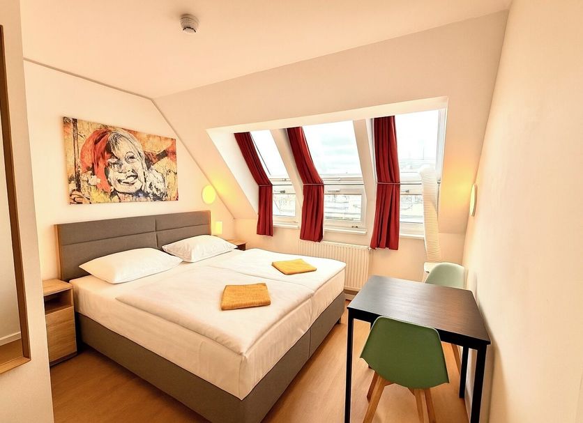 A&T Hotel & Hostel Vienna guest room with double bed, desk, and window seats