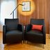 Auberge A La Chouenne in La Malbaie: two black armchairs, floor lamp, and wood-paneled wall