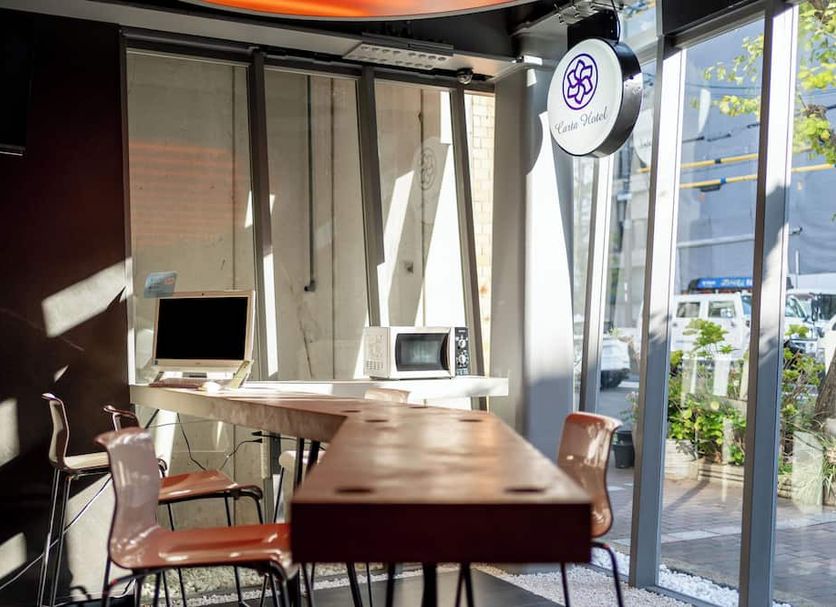 Carta Hotel Kyoto Gion in Kyoto lobby with curved desk, chairs, and floor-to-ceiling windows