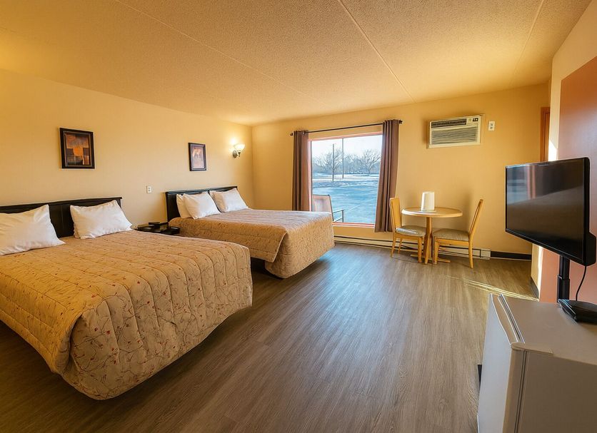 Motel St-Eustache room in Saint-Eustache with two beds, desk, TV and window view