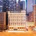 Dalian Jinbai International Hotel in Dalian, city-center façade lit at dusk amid high-rises
