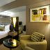 TIME Grand Plaza Hotel Dubai room with king bed, armchair, mirrored wall and abstract artwork.